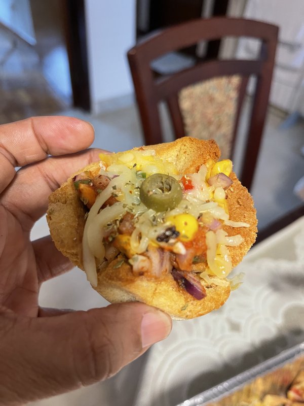 Pizza Bread Cups filled with corn, diced tomatoes, beans, and melted cheese, served in small tortilla or bread cups arranged in a foil tray.
