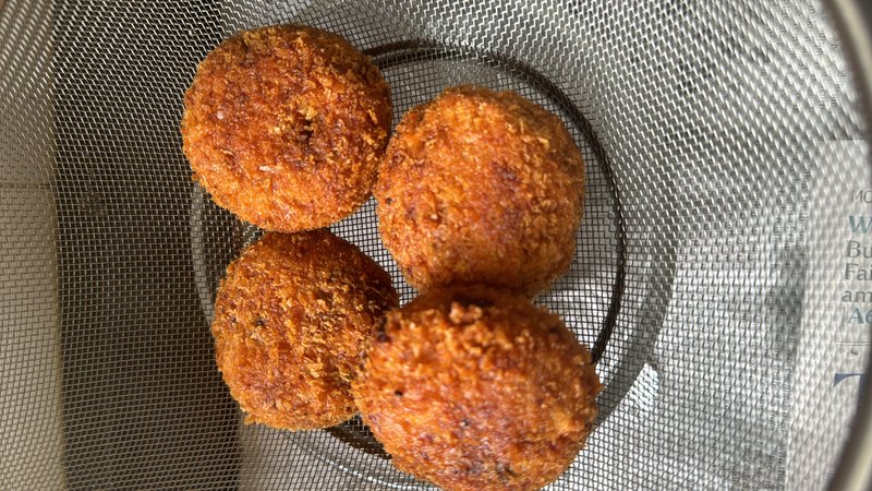 Veg Cutlet — four golden-brown, round-shaped fried vegetable patties resting on a wire mesh rack, with a crispy, breadcrumb-coated exterior.